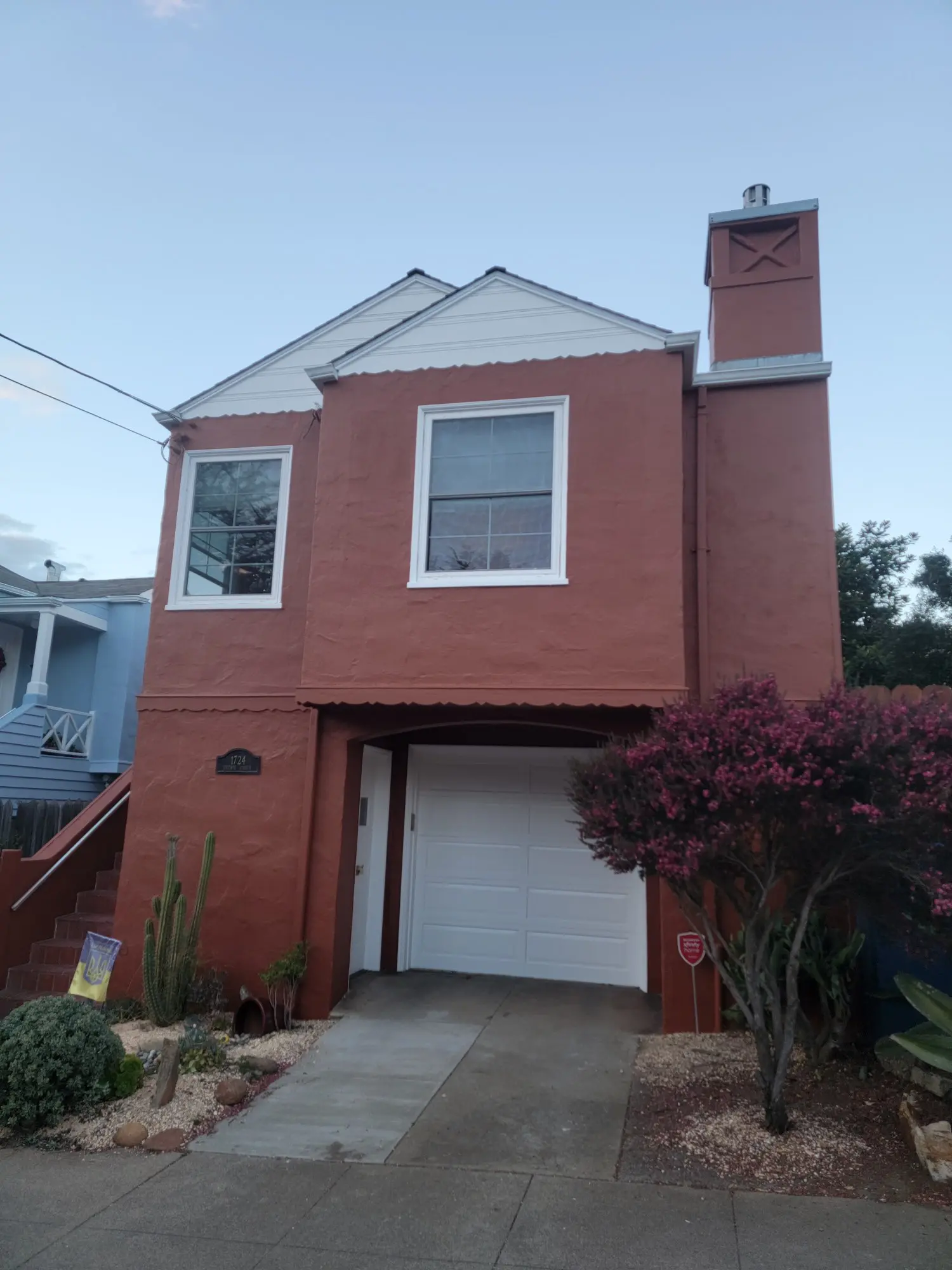 Two-story brick house with a garage and chimney.