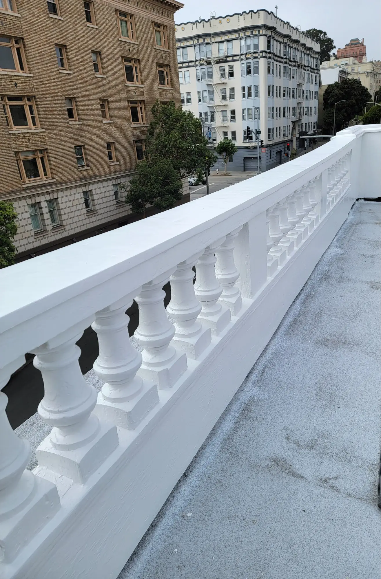 White balcony railing with classic balusters on a rooftop.