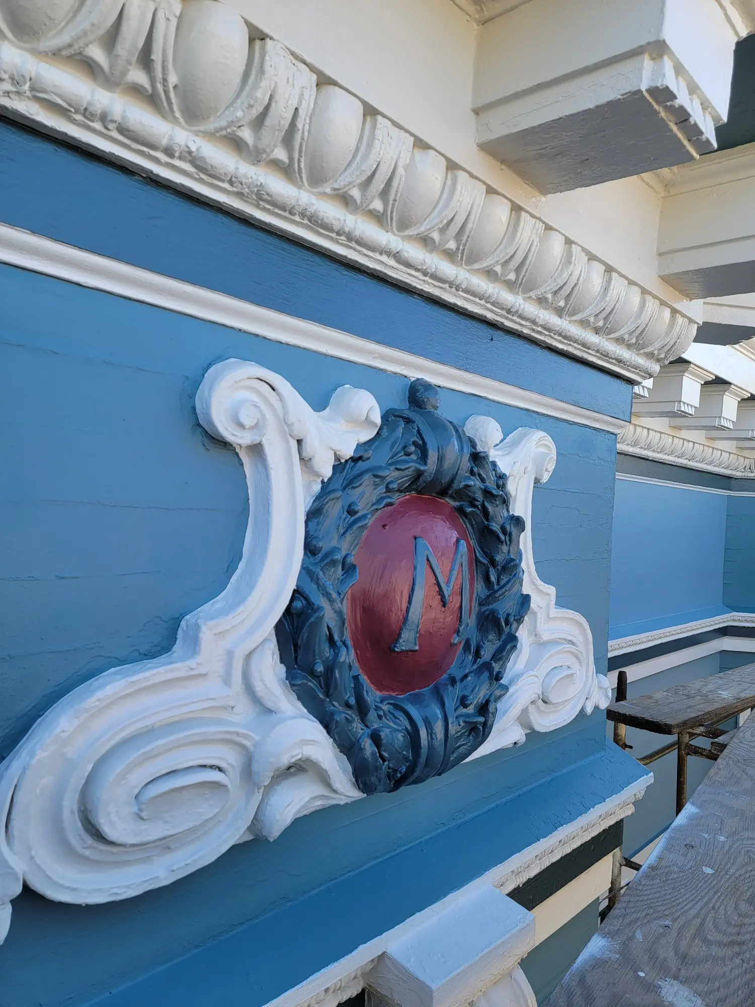 Decorative emblem with a red 'N' on a blue wall.