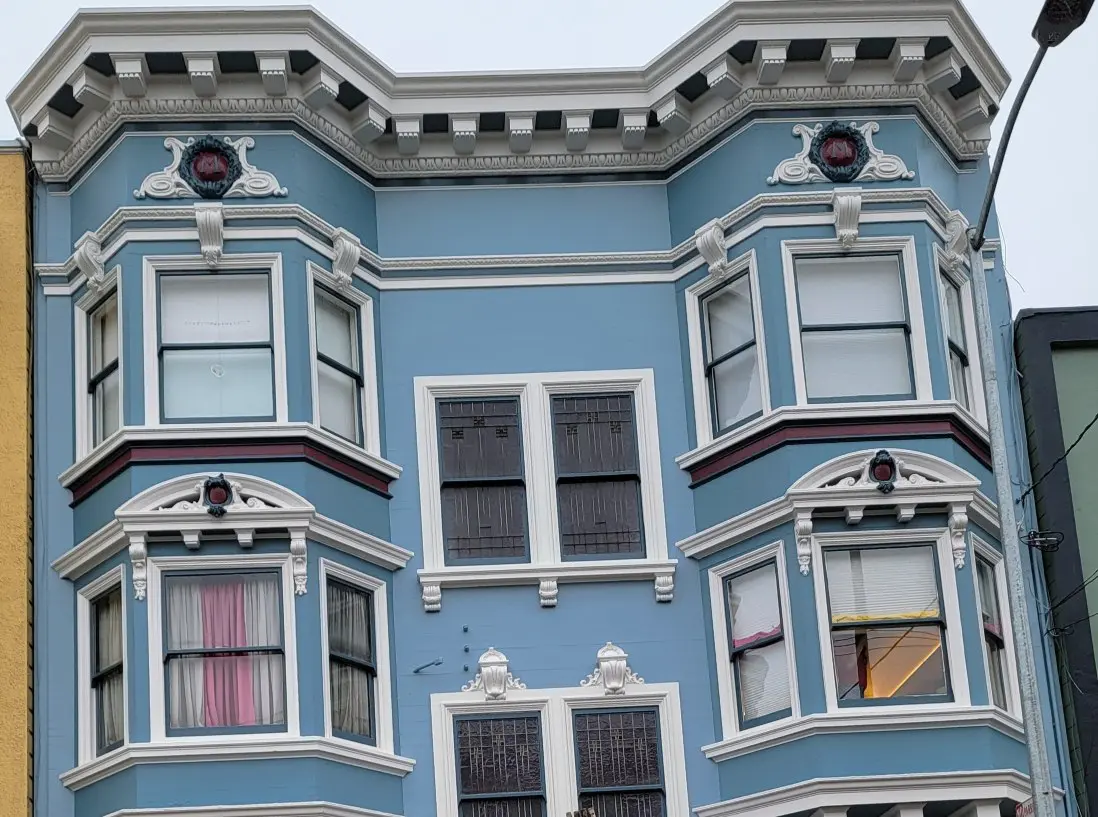 Blue Victorian-style building facade with ornate window details.