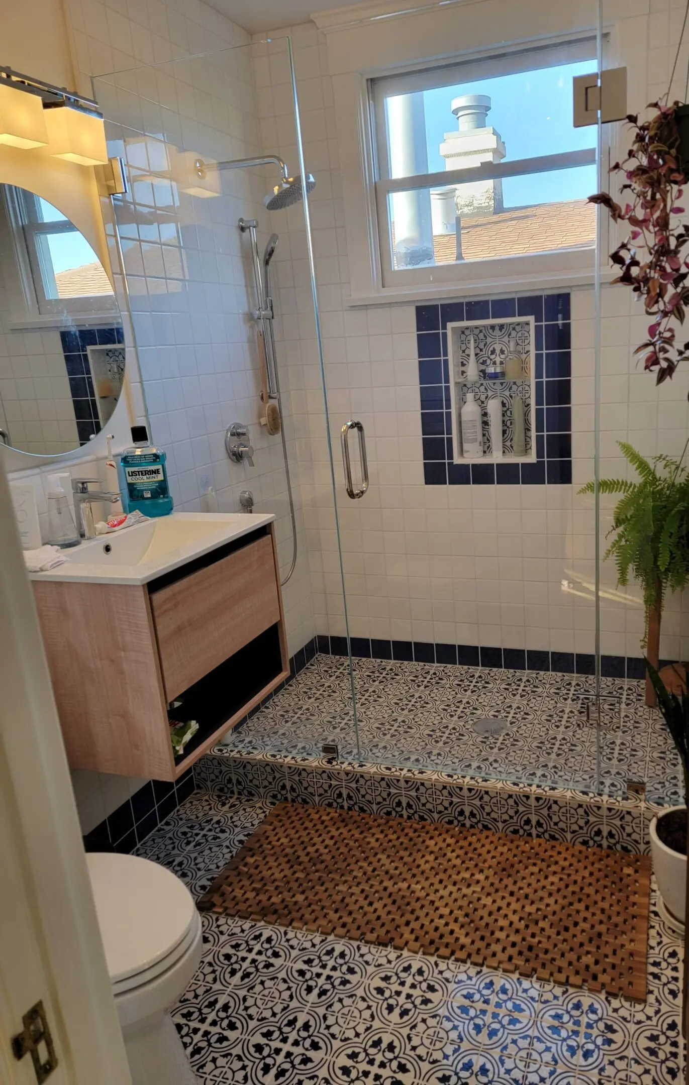 Modern bathroom with wooden vanity and tiled floor.