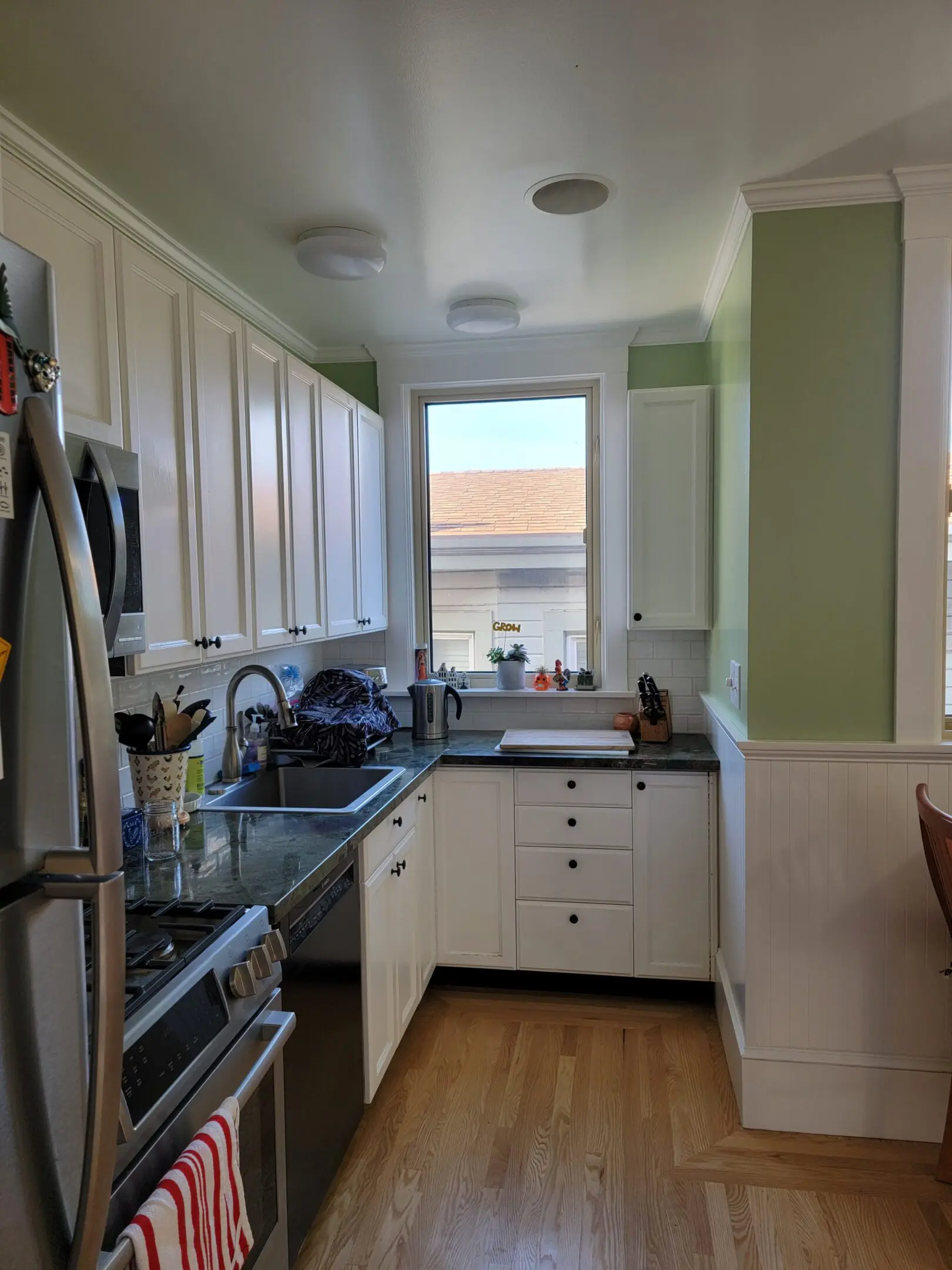 Bright kitchen with white cabinets, a window, and modern appliances.
