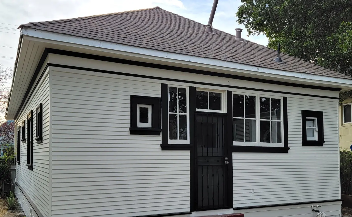 A small white house with black-trimmed windows and door.