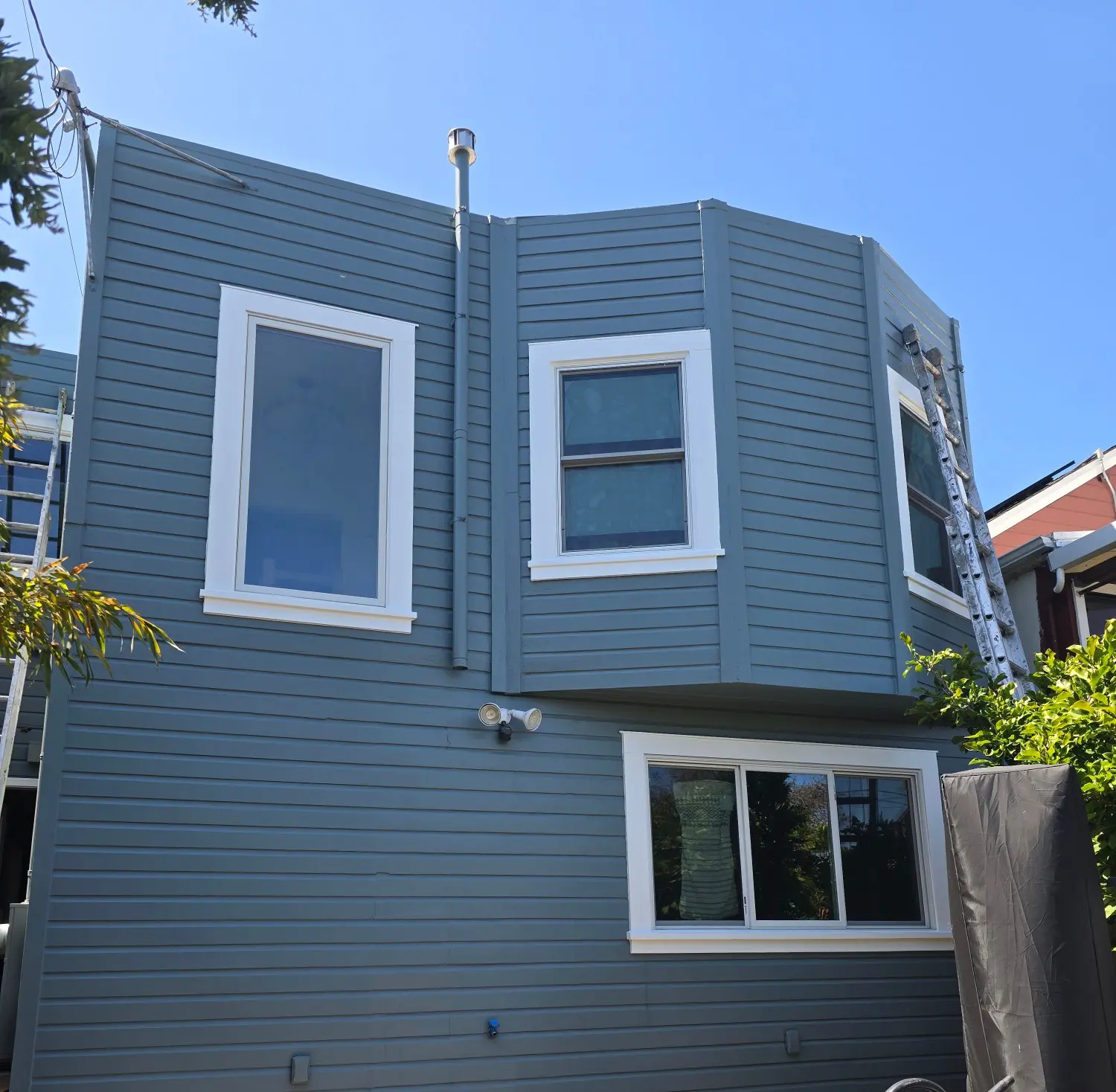 Blue two-story house with white window frames.