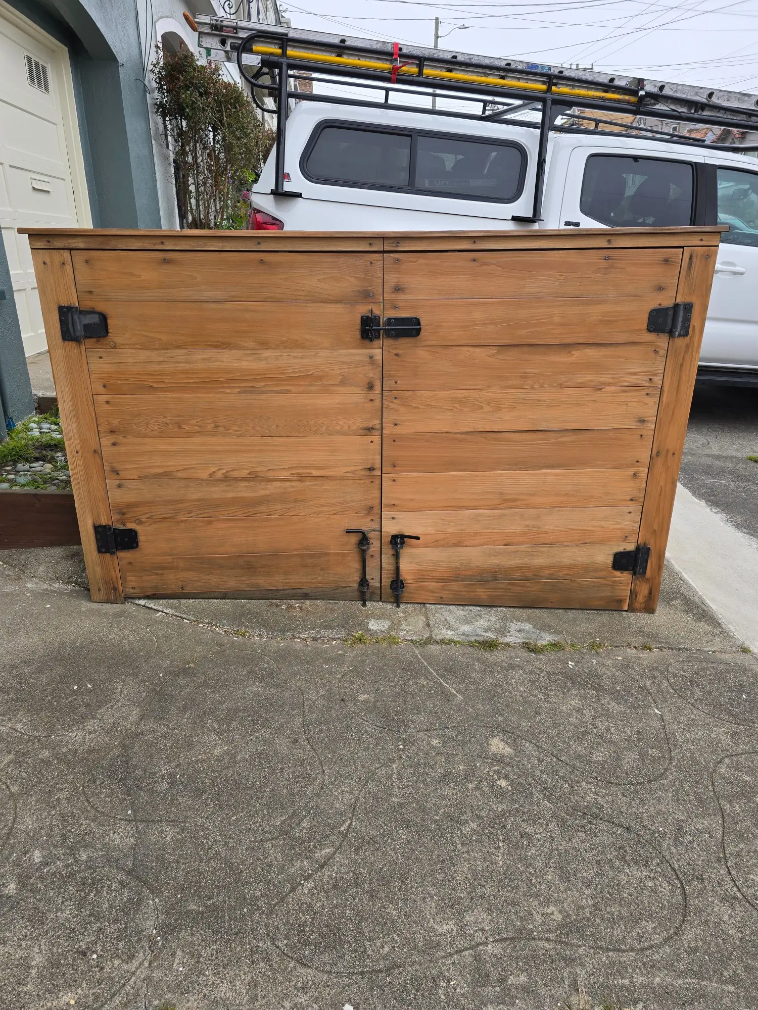 Wooden outdoor storage box with metal hinges and latches.