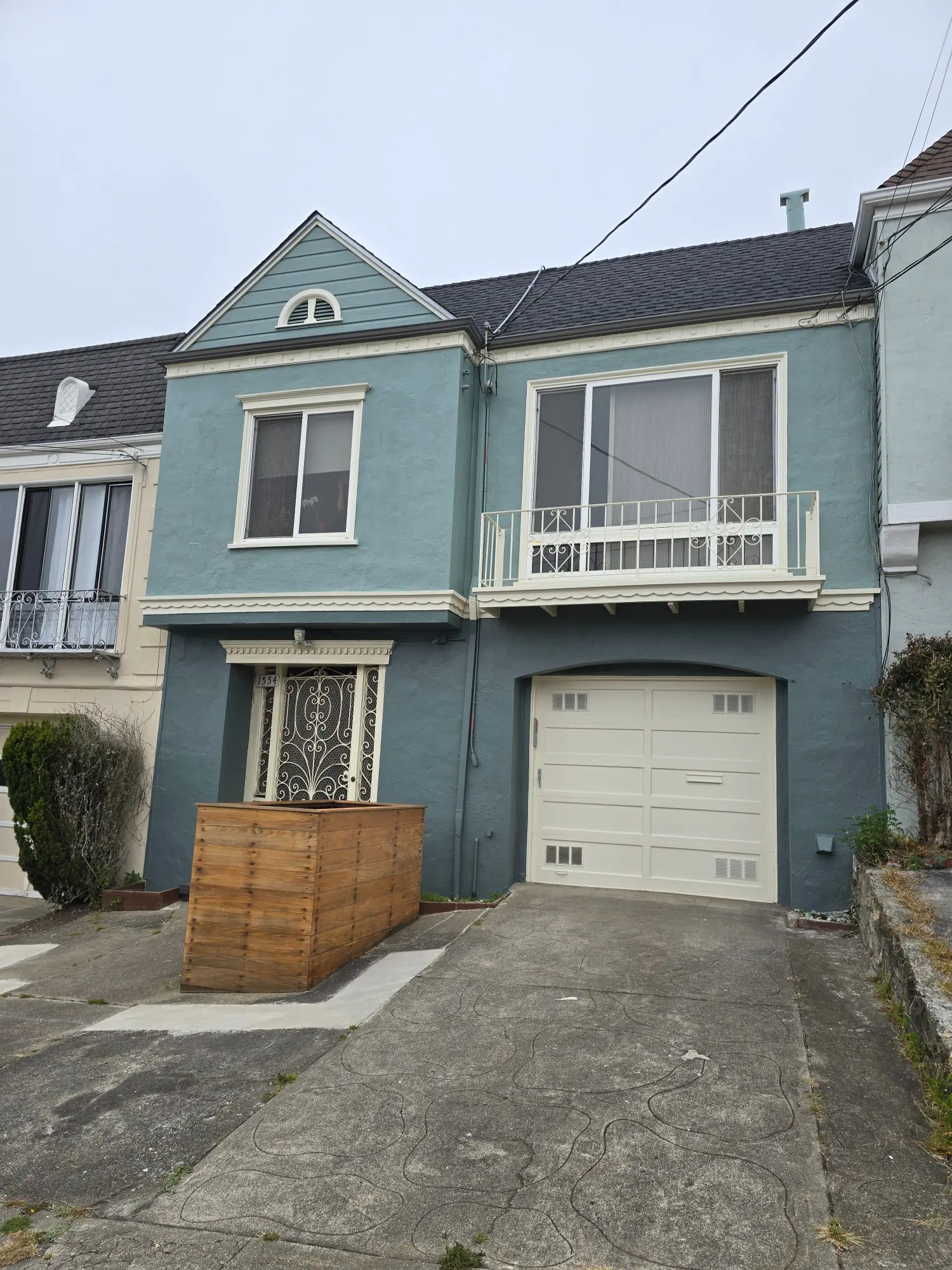 Blue two-story house with a garage and balcony.