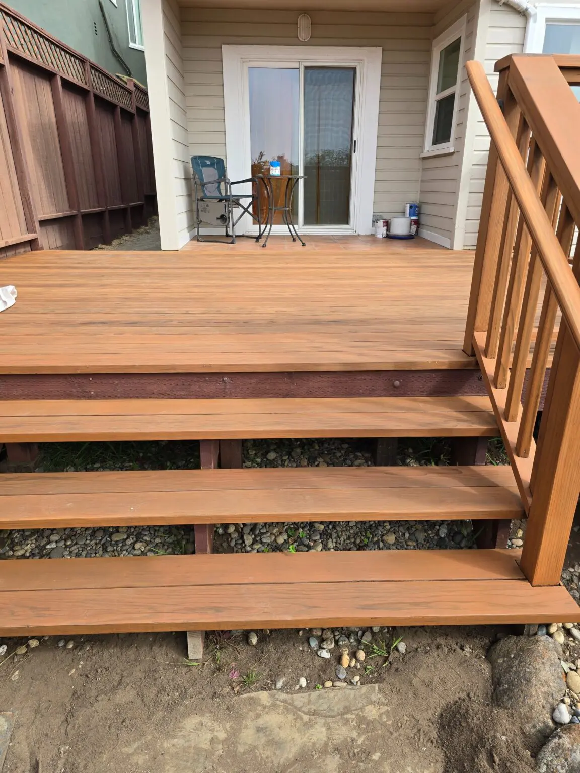 Wooden deck with stairs leading to a house entrance.
