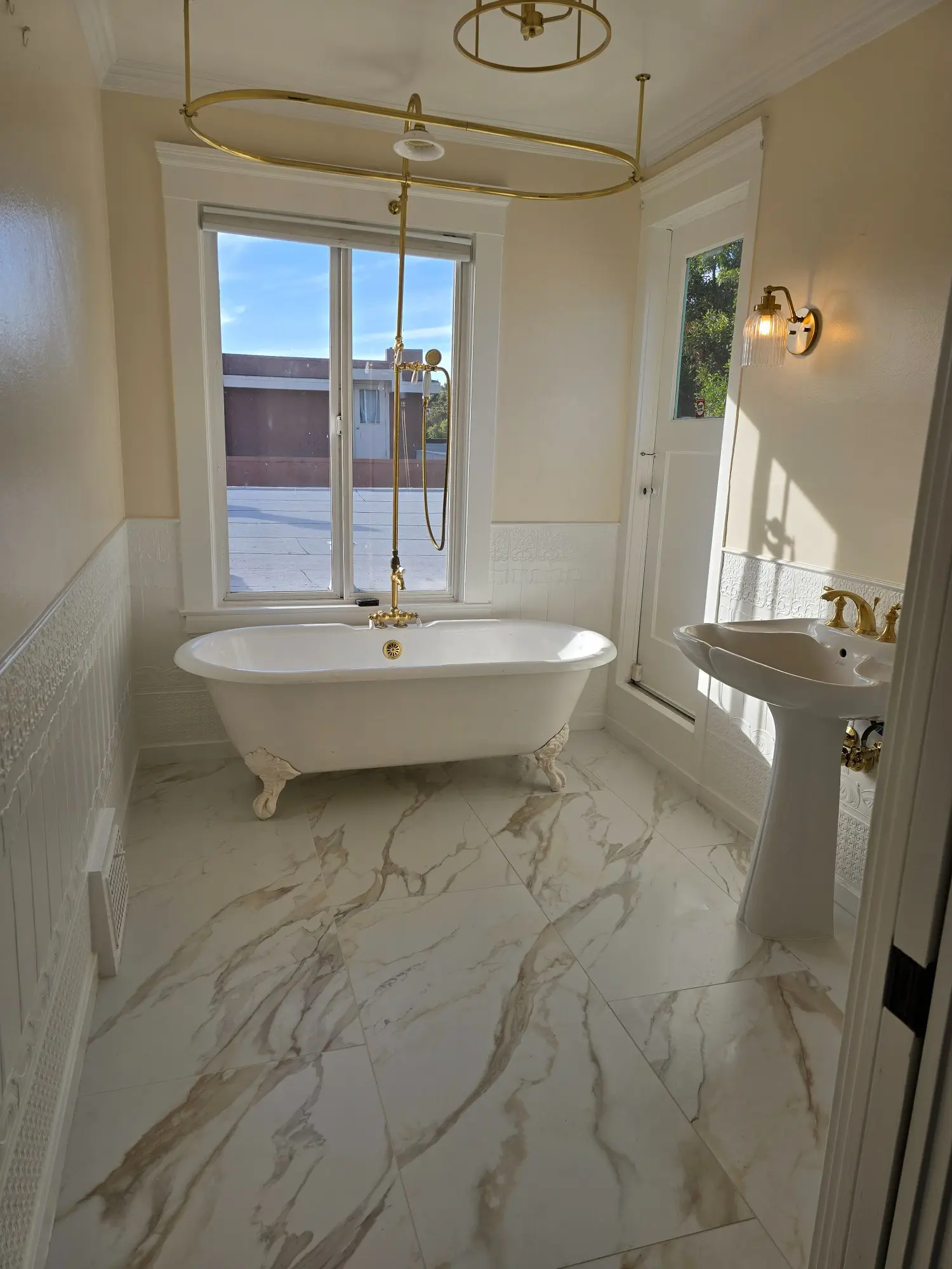 Elegant bathroom with a freestanding tub and marble-style flooring.