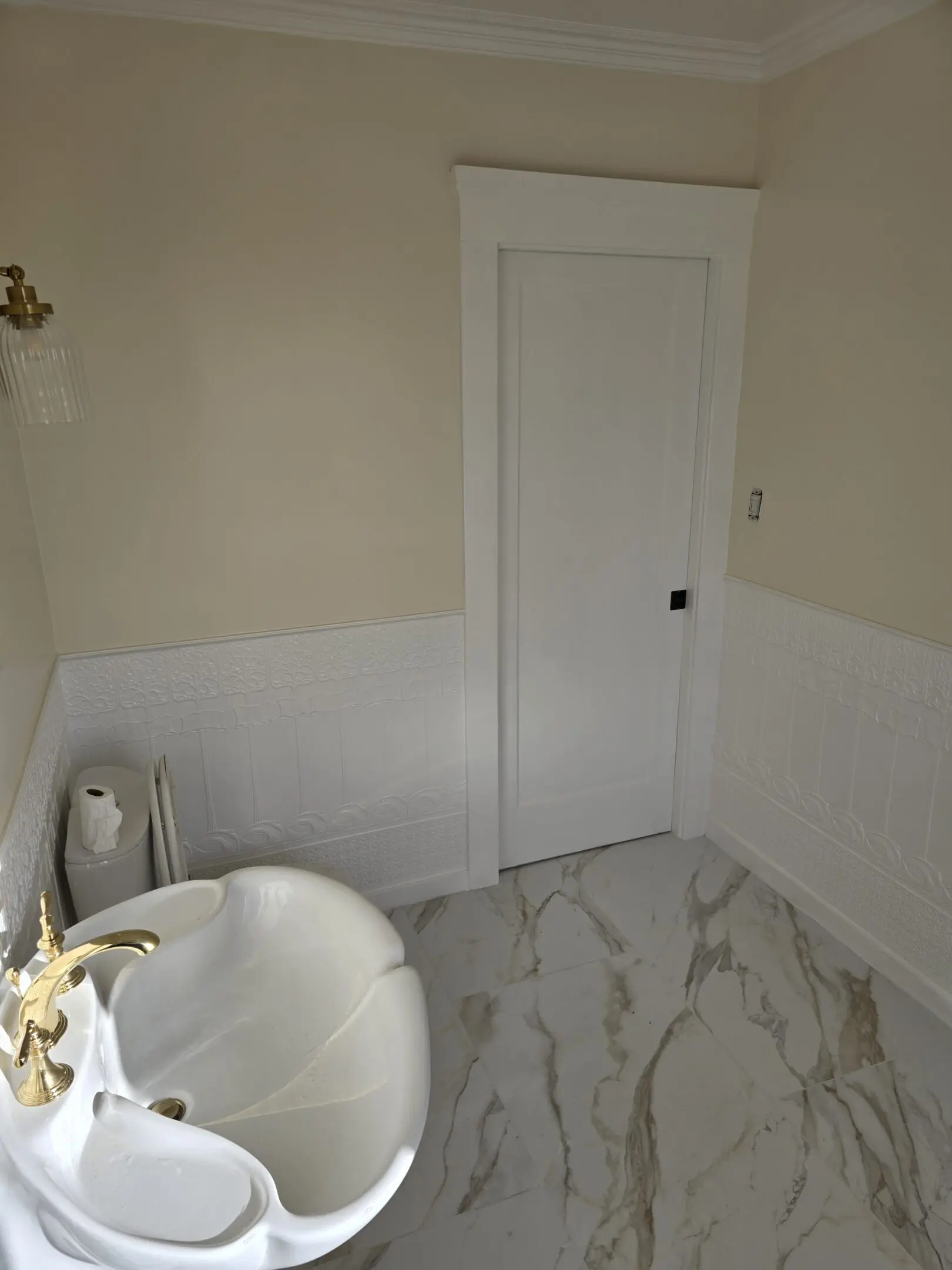 Minimalist bathroom with a white door and marble floor.