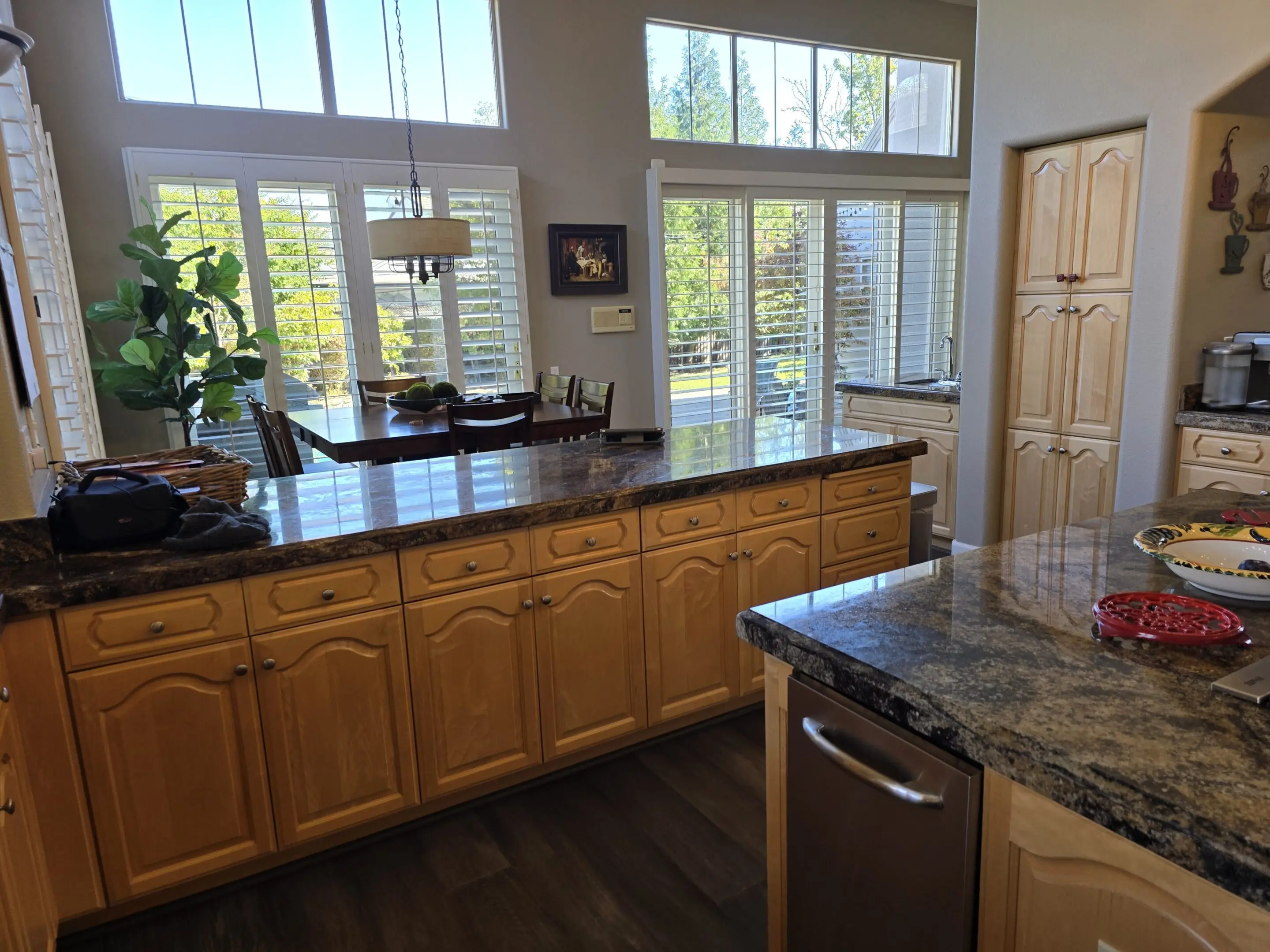 Bright kitchen with wooden cabinets and large windows letting in natural light.