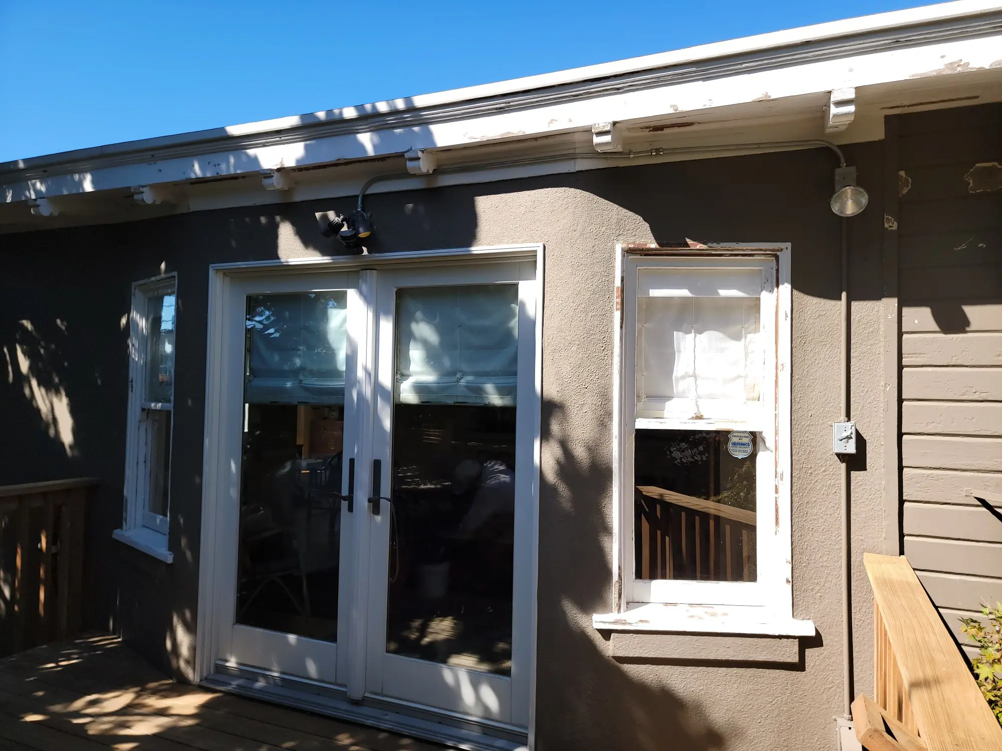 Exterior view of a small building with glass doors and a window.