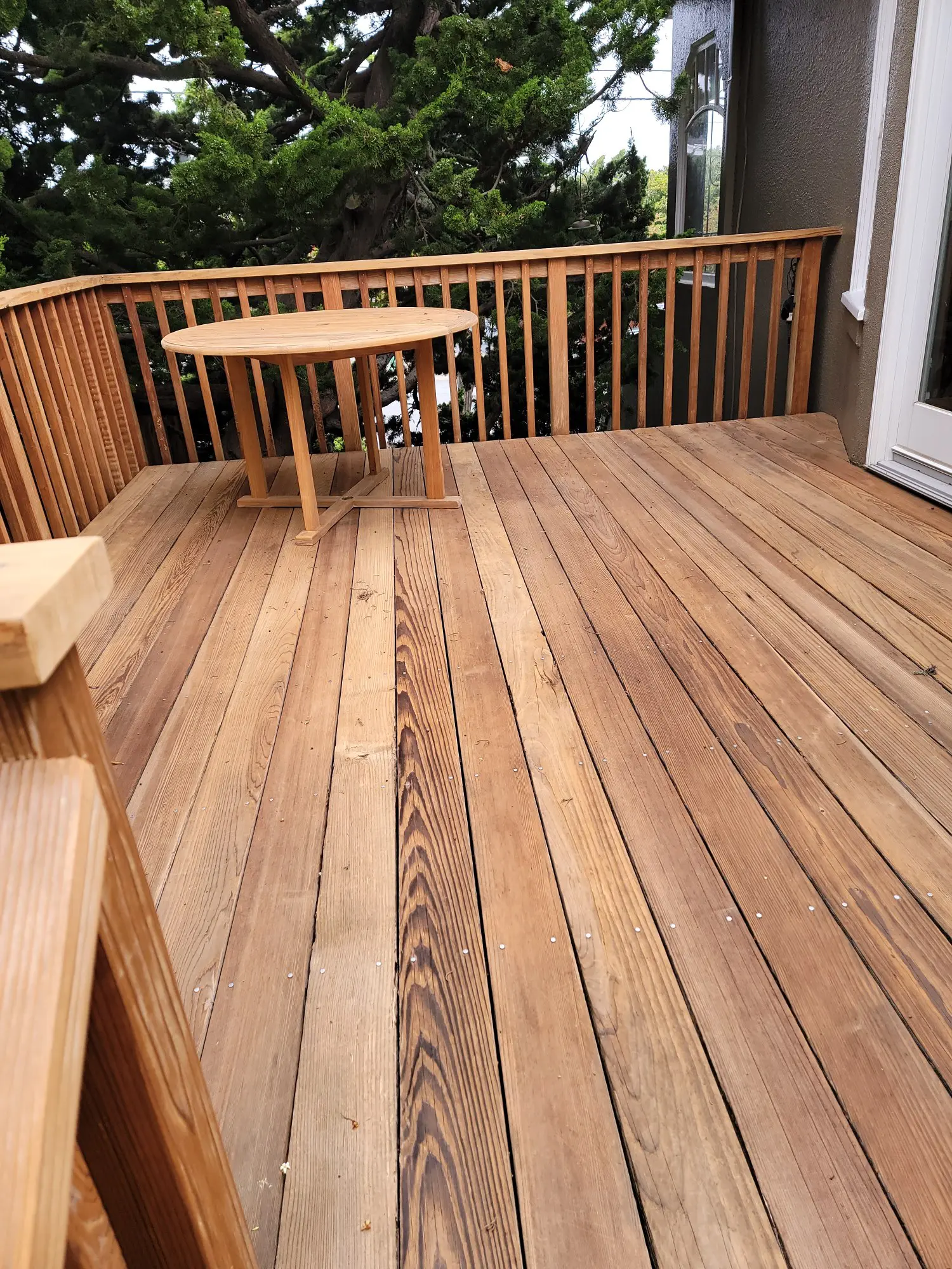 Wooden deck with a table and bench seating outdoors.