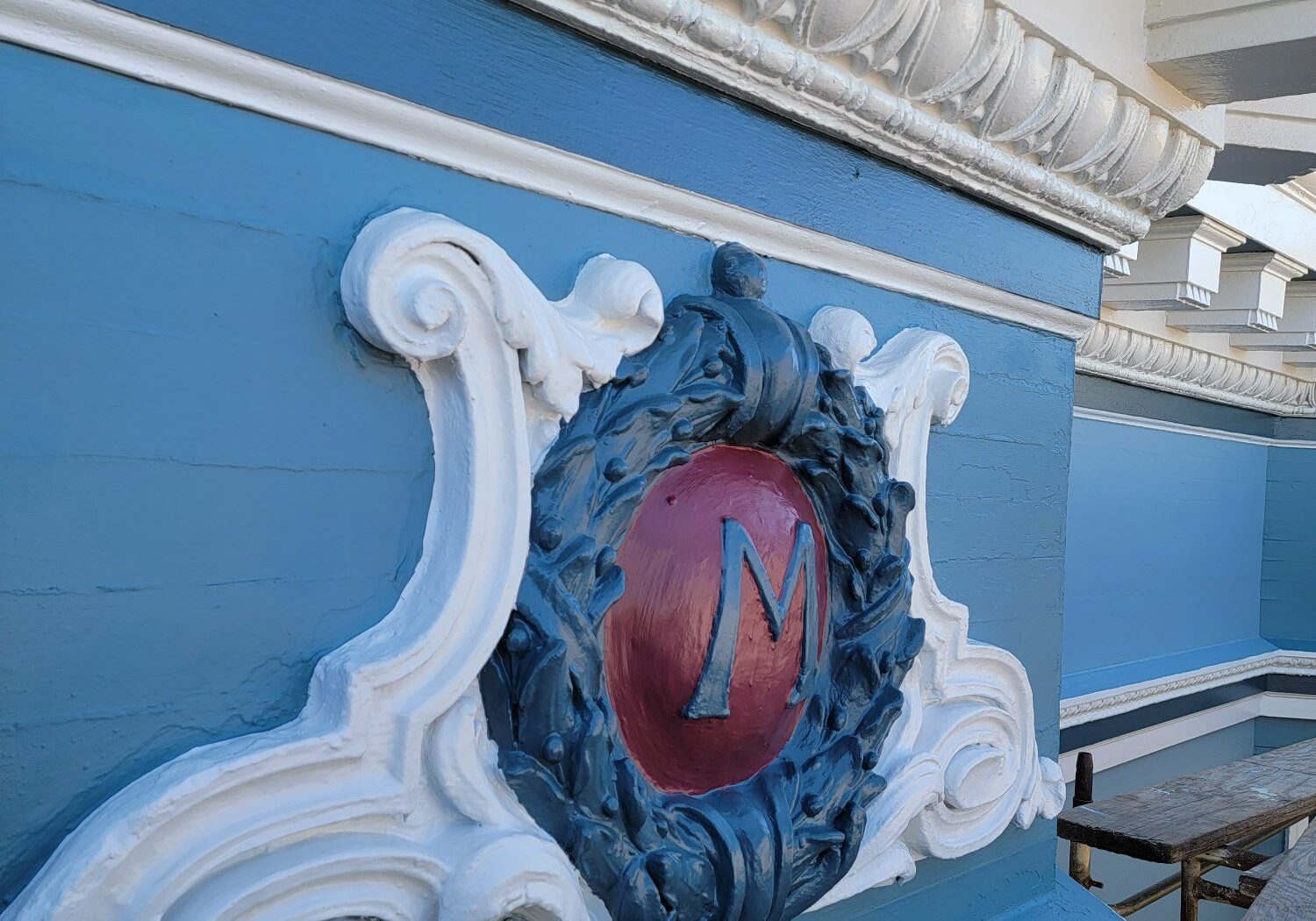 Decorative emblem with a red 'N' on a blue wall.
