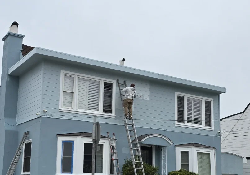 House painting in progress, cloudy day